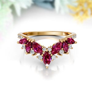 Peut inclure: Une bague en or avec un design en forme de V ornée de pierres de rubis en forme de marquise et de diamants ronds.