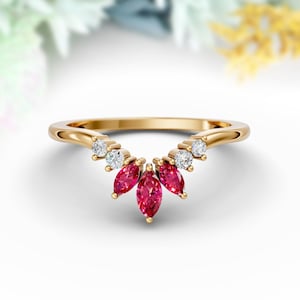 May include: A gold band ring with a curved design featuring a row of small round diamonds and a cluster of five marquise-shaped red gemstones.