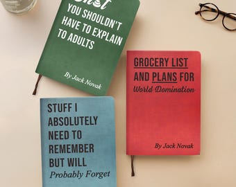 May include: Three hardcover notebooks in green, red, and blue, each with unique text. The green notebook reads "Sh*t You Shouldn't Have to Explain to Adults." The red notebook says "Grocery List and Plans for World Domination." The blue notebook says "Stuff I Absolutely Need to Remember But Will Probably Forget."