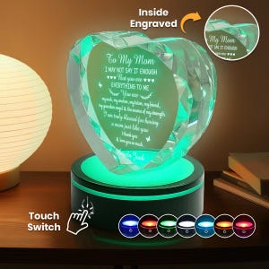 Puede incluir: Un recuerdo de cristal en forma de coraz&oacute;n con un mensaje grabado para una madre, iluminado por una base LED que cambia de color. El texto dice "To My Mom" e incluye un mensaje personal. La base presenta un interruptor t&aacute;ctil y varias opciones de color.