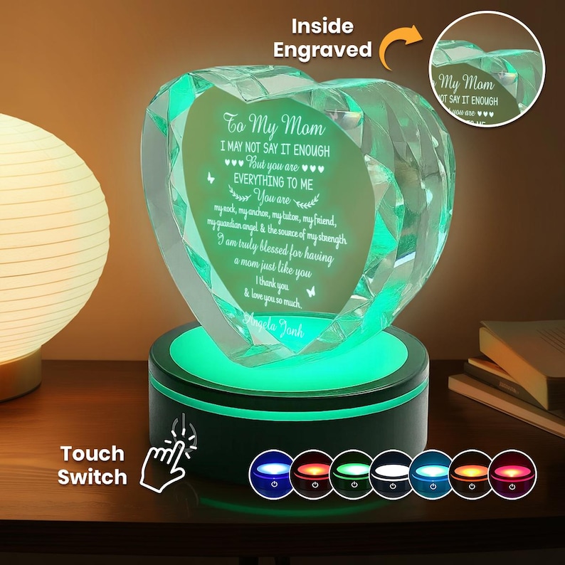 Puede incluir: Un recuerdo de cristal en forma de coraz&oacute;n con un mensaje grabado para una madre, iluminado por una base LED que cambia de color. El texto dice "To My Mom" e incluye un mensaje personal. La base presenta un interruptor t&aacute;ctil y varias opciones de color.