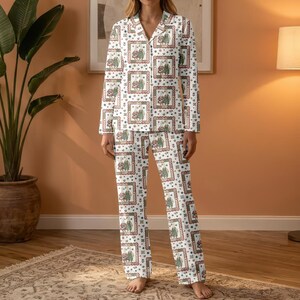 May include: White pajama set with a repeating pattern of framed illustrations, hearts, and dots in shades of green, red, and brown. The long-sleeved top has a collared neckline and button-down front. The matching pants have a straight leg.