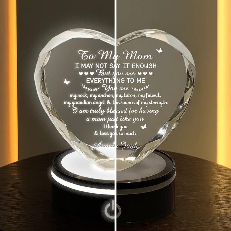 Puede incluir: Un cristal transparente en forma de coraz&oacute;n con un mensaje grabado para una madre, sobre una base negra iluminada. El texto incluye frases como "To My Mom" y "Everything to Me."