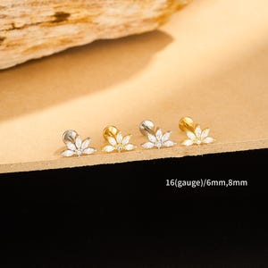 Pode incluir: Quatro peças de joalharia, cada uma com um design floral com pedras claras e brilhantes. Duas são prateadas e duas douradas. O texto "16(gauge)/6mm,8mm" é visível. Provavelmente são brincos ou joias corporais.