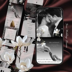 Op de afbeelding: Een trouwuitnodigingssuite met een smartphone met een zwart-witfoto van een kussend stel, omringd door witte magnoliabloemen. Extra uitnodigingskaarten met evenementdetails en data zijn zichtbaar.