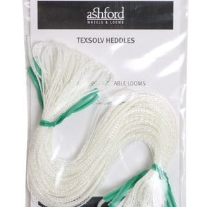 May include: A clear plastic bag containing white Texsolv heddles for looms, manufactured by Ashford Wheels & Looms. The heddles are bundled with green plastic ties. The packaging includes a white card with black text identifying the product.