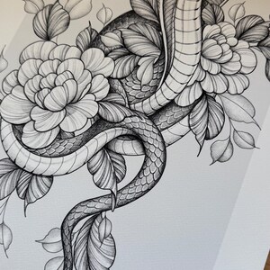 May include: Detailed black and white illustration of a cobra intertwined with flowers and leaves. The snake is the focal point, with scales and intricate details. The floral elements add a delicate contrast to the snake's form.
