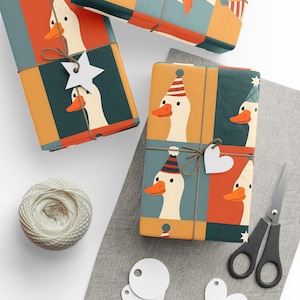 May include: Gift-wrapped presents with a whimsical goose design. The wrapping paper features a repeating pattern of geese wearing party hats, in shades of orange, teal, and cream. Twine and decorative tags add a rustic touch. Scissors and string are also visible.