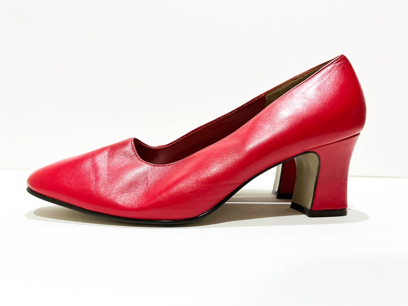 Puede incluir: Un par de zapatos de sal&oacute;n de cuero rojo con tac&oacute;n de bloque.
