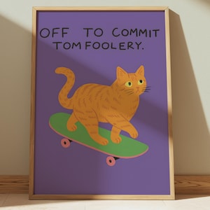 May include: A framed print featuring an orange cat riding a green skateboard against a purple background. The text "OFF TO COMMIT TOM FOOLERY" is at the top. The artwork has a playful, cartoonish style, perfect for a kid's room or a fun space.