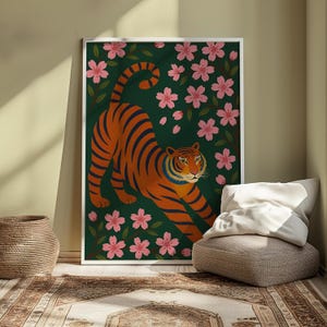 May include: A framed art print featuring an orange tiger with dark blue stripes, stretching among pink cherry blossoms on a dark green background. The artwork is in a white frame, creating a striking contrast.
