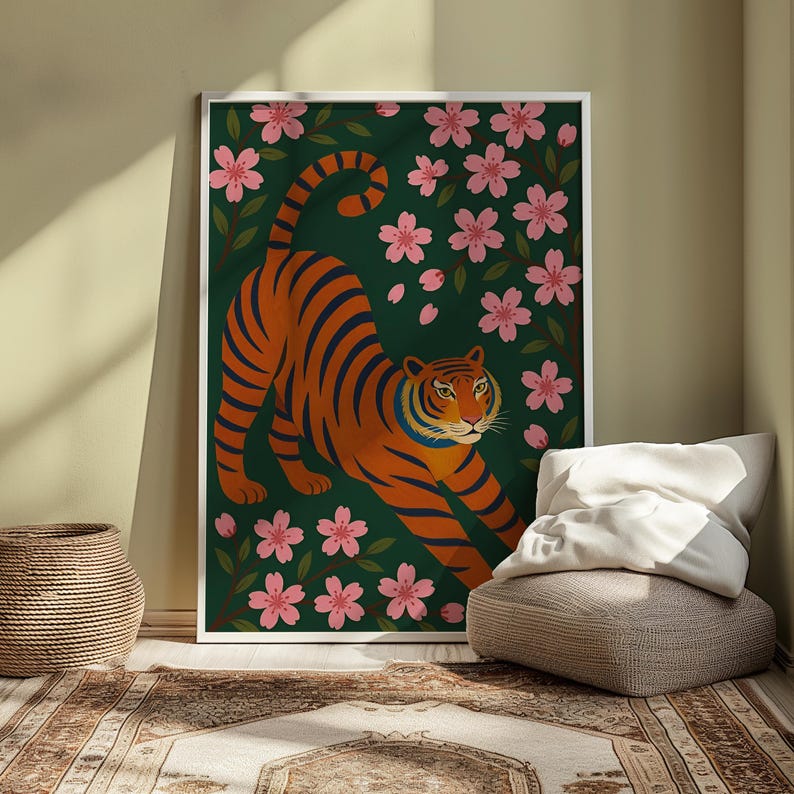 May include: A framed art print featuring an orange tiger with dark blue stripes, stretching among pink cherry blossoms on a dark green background. The artwork is in a white frame, creating a striking contrast.