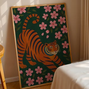 May include: A framed art print featuring a stylized tiger with orange and black stripes, set against a dark green background with pink cherry blossoms. The tiger is in a stretching pose, creating a dynamic composition.