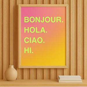 Może przedstawiać: Oprawiony wydruk z gradientowym tłem w kolorze różowym, pomarańczowym i żółtym. Na wydruku widnieją słowa "BONJOUR. HOLA. CIAO. HI." w jaskrawozielonym kolorze. Mały beżowy wazon i stos książek stoją na drewnianej półce.