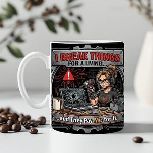 Könnte beinhalten: Weiße Keramiktasse mit schwarzer Grafik. Das Design zeigt eine Frau mit Brille und Kopfhörern, die einen Bohrer vor einem kaputten Laptop hält. Der Text lautet "I BREAK THINGS FOR A LIVING... and They Pay Me for It."