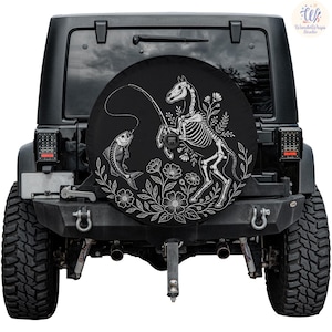 May include: Black spare tire cover featuring a white illustration of a horse skeleton fishing for a fish skeleton. The design includes floral elements. The cover is mounted on a black Jeep.