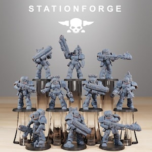 May include: A collection of gray miniature figurines of armored soldiers, each holding a weapon. The figurines are arranged on a tiered display, with the word "STATIONFORGE" and a skull logo at the top.