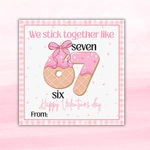 May include: A Valentine's Day card with a pink and white gingham border. The card features a pink frosted number six and seven, designed to look like cookies. The text reads "We stick together like seven six Happy Valentine's day" and "From:"