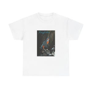 May include: White t-shirt with a vibrant illustration of a kingfisher. The design shows the bird in flight against a dark backdrop, with the word "Kingfisher" written above in a script font.