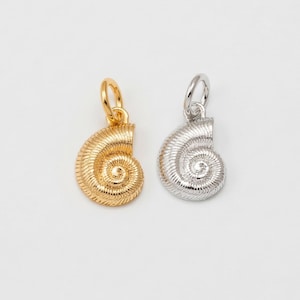 May include: Two seashell-shaped pendants. One is gold-colored, the other is silver-colored. Both have a spiral design and a small loop at the top for attaching to a chain or bracelet. The pendants are displayed on a white background.