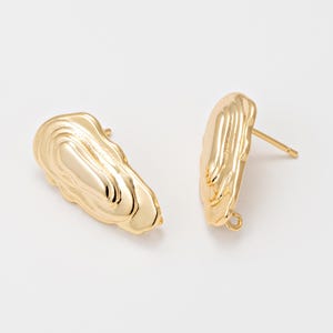 May include: Two gold stud earrings with an organic, textured design. Each earring has a post for piercing. The earrings are set against a white background, highlighting their metallic sheen and unique shape. The earrings are a jewelry item.