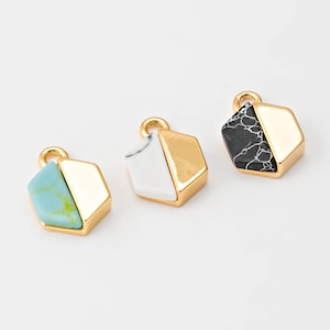 May include: Three geometric pendants with gold-colored metal frames. One pendant features a turquoise and yellow stone, another a white stone, and the third a black and white marbled stone. Each has a small loop for hanging.