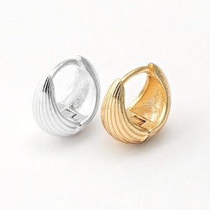 Może przedstawiać: Para kolczyków koła, jeden złoty, a drugi srebrny, z żebrowanym wzorem.