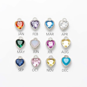 May include: Twelve silver heart-shaped charms with different colored gemstones, representing each month of the year. January is red, February is purple, March is blue, April is clear, May is green, June is white, July is pink, August is yellow, September is blue, October is pink, November is yellow, and December is turquoise.