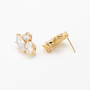 Può includere: Un paio di orecchini a bottone dorati. Un orecchino presenta un gruppo di tre pietre chiare e scintillanti. L'altro orecchino ha un design lineare con quattro pietre chiare. Entrambi gli orecchini hanno un perno e un retro.