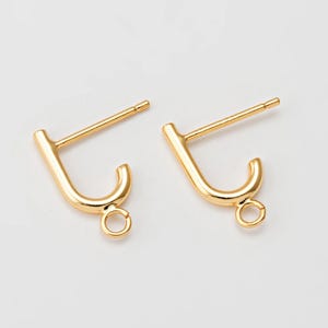 May include: A pair of gold-tone earring findings with a loop at the bottom. The findings are designed to be used with a variety of earrings.