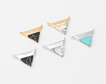 May include: Five triangle-shaped jewelry pendants in gold and silver tones. Each pendant features a different stone inlay: black, white, and turquoise. The pendants have small loops for attaching to a chain or other jewelry component.