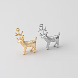 May include: Two small, metallic reindeer figurines. One is gold, the other silver. Both have detailed antlers and stand on four legs. The reindeer are likely decorative items, possibly for holiday or seasonal use.