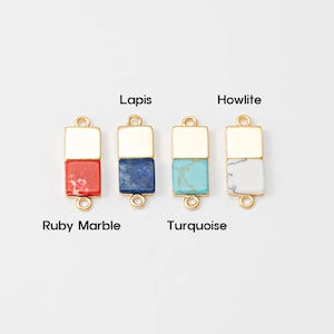 Pode incluir: Quatro pingentes retangulares de pedras preciosas com detalhes em metal dourado. Os pingentes são rotulados como Ruby Marble, Lapis, Turquoise e Howlite. Cada pingente tem uma parte superior quadrada e uma inferior retangular, com um laço na parte superior e inferior.