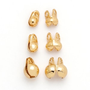 May include: Six gold-toned metal jewellery findings, some are round and some are shaped like a heart.