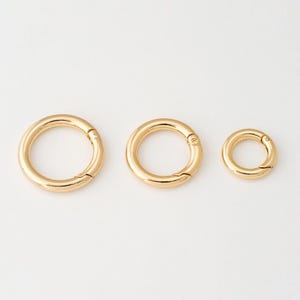 Puede incluir: Tres llaveros de metal de color dorado de diferentes tamaños. Los llaveros están abiertos y listos para usar.