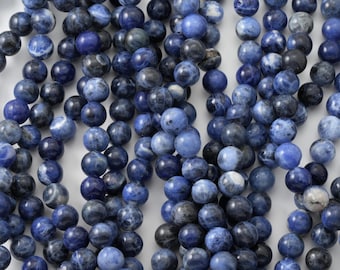 May include: Strands of round, polished sodalite beads in varying shades of blue and gray. The beads are strung together, creating a textured and visually appealing display. Ideal for jewelry making or crafting projects.