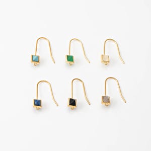 May include: Six pairs of gold-colored earrings with square-shaped gemstones in various colors: turquoise, green, cream, blue, black, and gray. The earrings have a simple hook design.