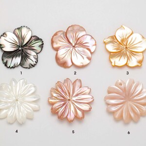Puede incluir: Seis colgantes con forma de flor en varios colores. Los colgantes est&aacute;n hechos de n&aacute;car. Los colores incluyen negro iridiscente, melocot&oacute;n, dorado y blanco. Cada colgante tiene un dise&ntilde;o de p&eacute;talo diferente, algunos con un agujero para ensartar.