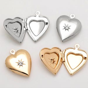 May include: Four heart-shaped locket pendants with a small rhinestone in the centre. Two pendants are silver and two are gold.
