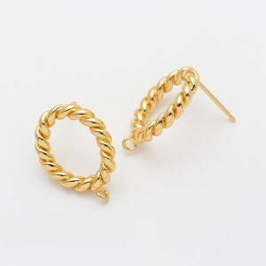 Op de afbeelding: Twee goudkleurige, open ovale oorbellen met een gedraaid touwontwerp. Eén oorbel ligt plat, terwijl de andere rechtop staat en de pin laat zien. De oorbellen staan tegen een witte achtergrond.