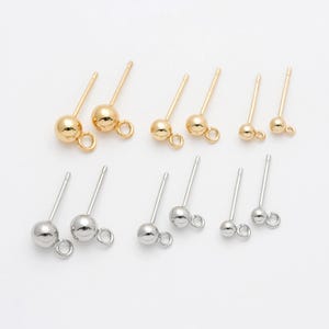 Puede incluir: Un juego de diez hallazgos de pendientes con una pequeña bola en el extremo y un bucle para sujetar joyas. Cinco son de color dorado y cinco son de color plateado.