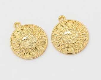 May include: Two gold-tone sun charm pendants with a face in the center of each sun. The sun has a detailed design with rays emanating from the center.