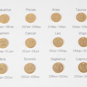 May include: Gold-colored round pendants, each engraved with a zodiac constellation and corresponding dates. The pendants are labeled with the zodiac signs: Aquarius, Pisces, Aries, Taurus, Gemini, Cancer, Leo, Virgo, Libra, Scorpio, Sagittarius, and Capricorn.