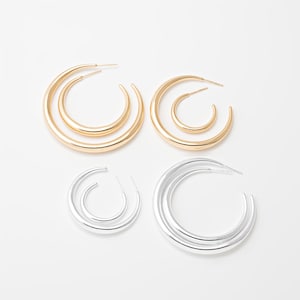 Könnte beinhalten: Vier Paar Creolen in Gold und Silber. Zwei Paare sind goldfarben, wobei ein Paar ein Doppelreifen-Design aufweist. Die anderen beiden Paare sind silberfarben, wobei ein Paar ein Doppelreifen-Design aufweist. Alle Ohrringe sind auf weißem Hintergrund.