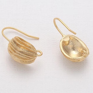 May include: Two gold-coloured earrings. Each earring features a hook and a textured, oval-shaped pendant. One pendant has a ribbed design, while the other has a smooth, open design. The earrings are set against a white background.