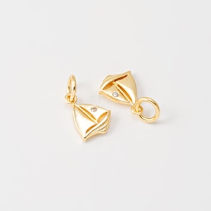May include: Two gold sailboat charms with a clear rhinestone on each. The charms have a loop for attaching to a bracelet or necklace.