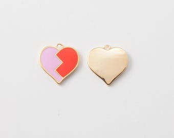 May include: Two heart-shaped pendants. One is divided into pink and red sections with a gold outline. The other is a solid gold heart. Both have a small loop at the top for hanging.