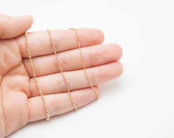 May include: Delicate gold-colored necklaces with different chain styles. One chain features small, evenly spaced beads, while the others have a classic link design. The jewelry is displayed against a plain white background.