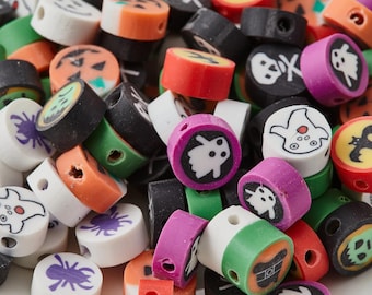 May include: A close-up of a pile of Halloween-themed beads in various colours. The beads feature designs like jack-o'-lanterns, ghosts, spiders, and skulls. Colours include orange, black, white, green, and purple. The beads are cylindrical with a hole through the centre.