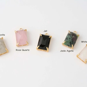 May include: Six gold-toned pendant charms with different colored gemstones. The charms are labeled with the names of the gemstones: Labradorite, Rose Quartz, Jet, Jade Agate, White Smoke.